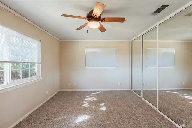 a view of a room with a ceiling fan and window