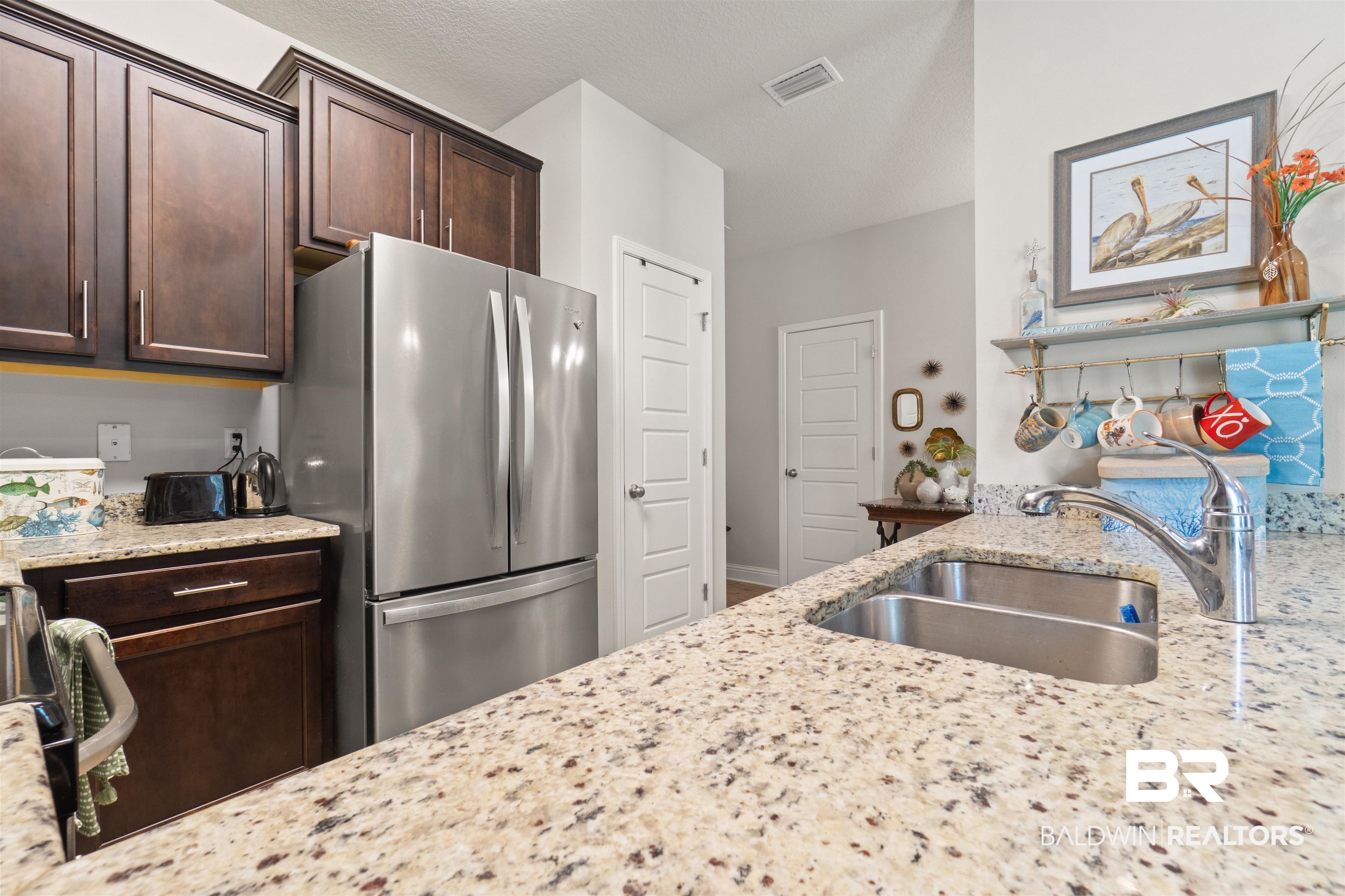 25806 Pollard Road, Unit 6 Daphne, AL 36526 - Photo 9 of 38 Kitchen featuring granite countertops, stainless steel undermount sink, and dark wood cabinetry