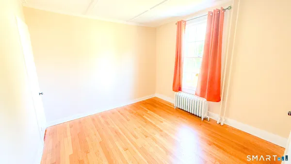 a view of a room with wooden floor and a window