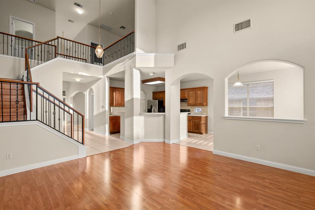 10105 Wind Cave Trail Austin, TX 78747 - Photo 4 of 23 Spacious interior featuring wood-finish flooring, high ceilings, and a grand staircase with wrought iron balusters