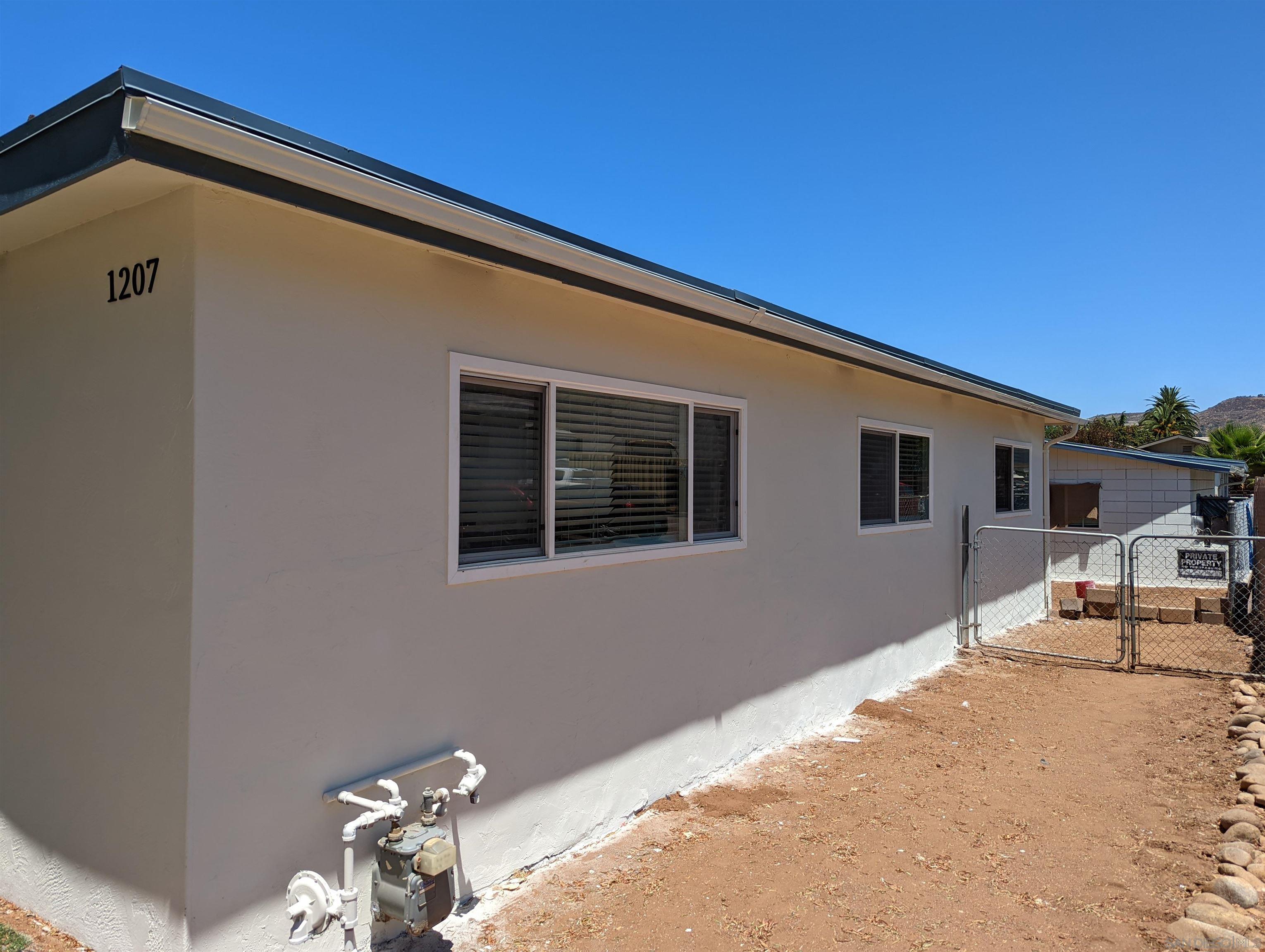 1207 Lyons Lane El Cajon, CA 92021 - Photo 2 of 39 a backyard of a house with table and chairs