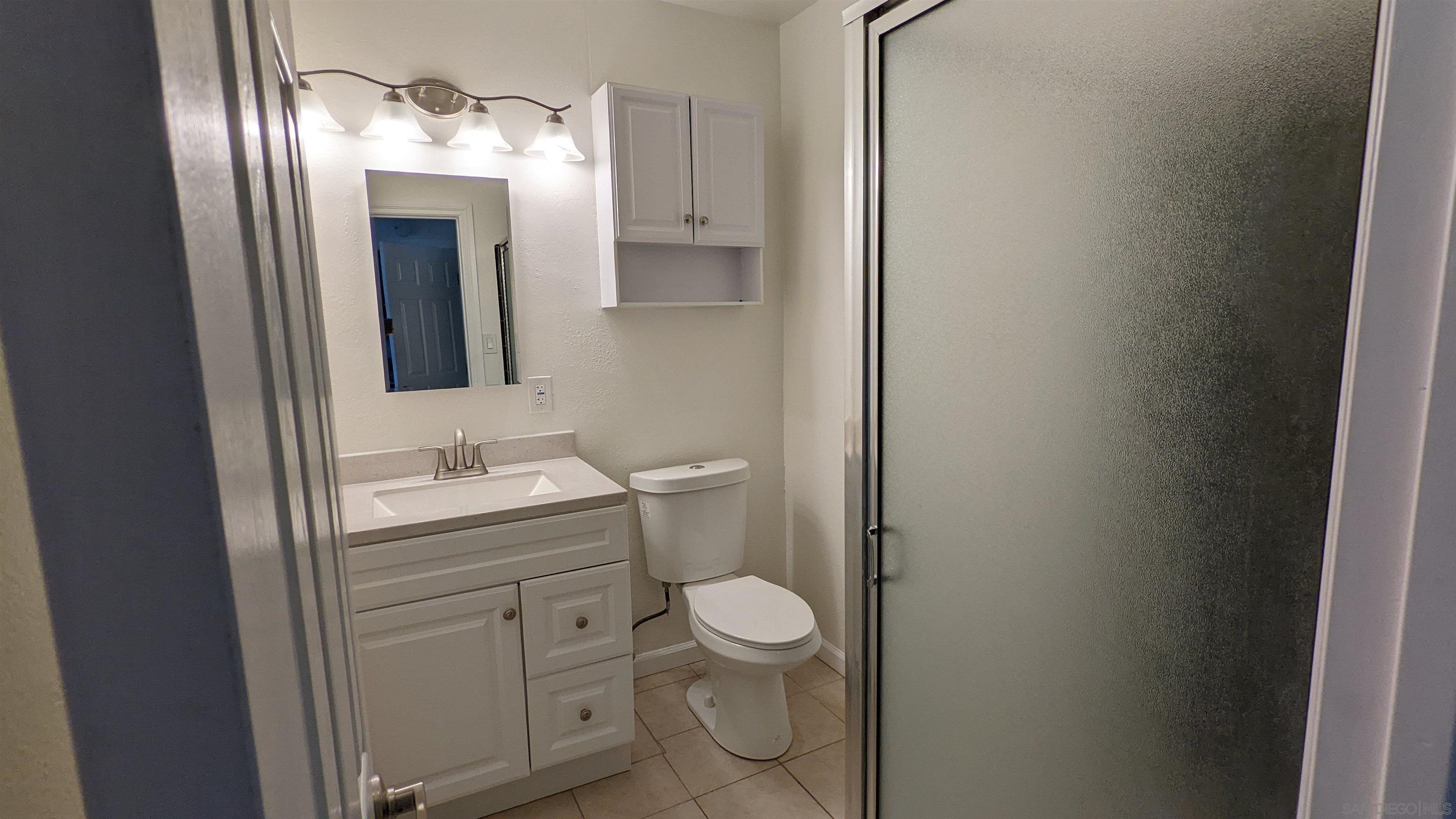 1207 Lyons Lane El Cajon, CA 92021 - Photo 25 of 39 a bathroom with a toilet sink and mirror