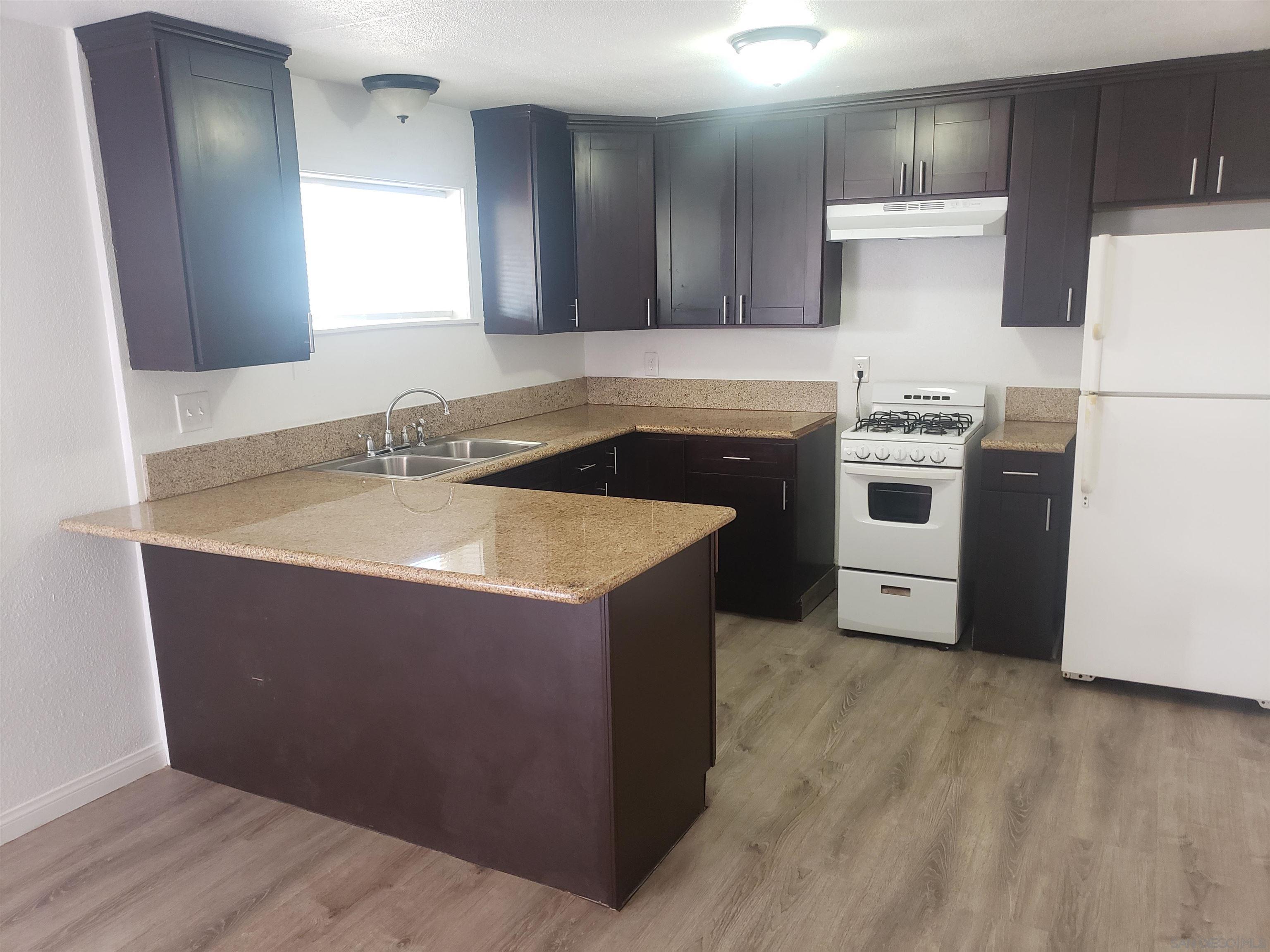 1207 Lyons Lane El Cajon, CA 92021 - Photo 30 of 39 a kitchen with a sink a stove a refrigerator and a microwave