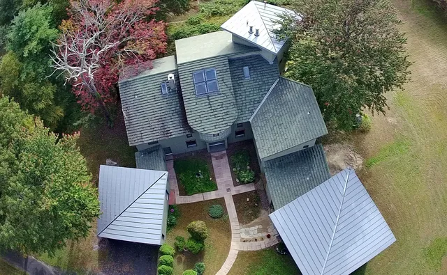 an aerial view of a house with roof deck and entertaining space