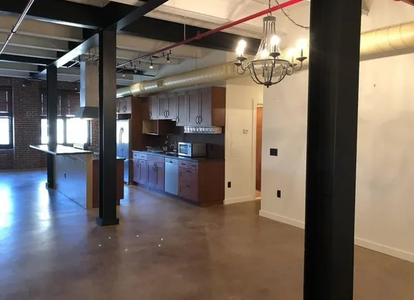 a open kitchen with yellow walls and chandelier