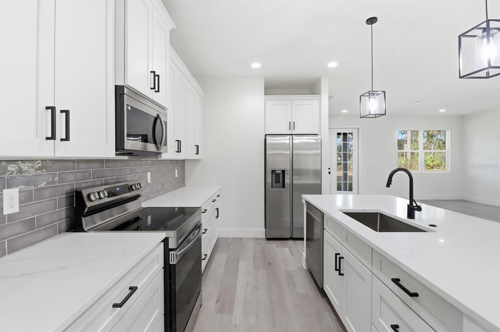 13250 Southwest 79th Circle Ocala, FL 34473 - Photo 14 of 44 a kitchen with refrigerator cabinets and a sink