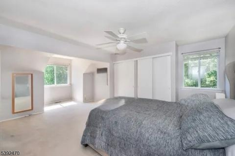 216 Woods Edge Drive Succasunna, NJ 07876 - Photo 12 of 13 a spacious bedroom with a large bed and a chandelier