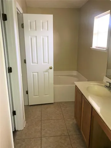 a bathroom with a granite countertop sink a mirror and a bathtub