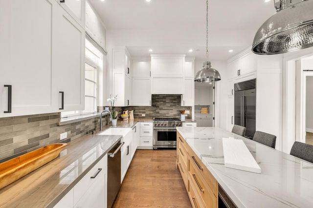 a large kitchen with kitchen island a large counter space a sink appliances and cabinets