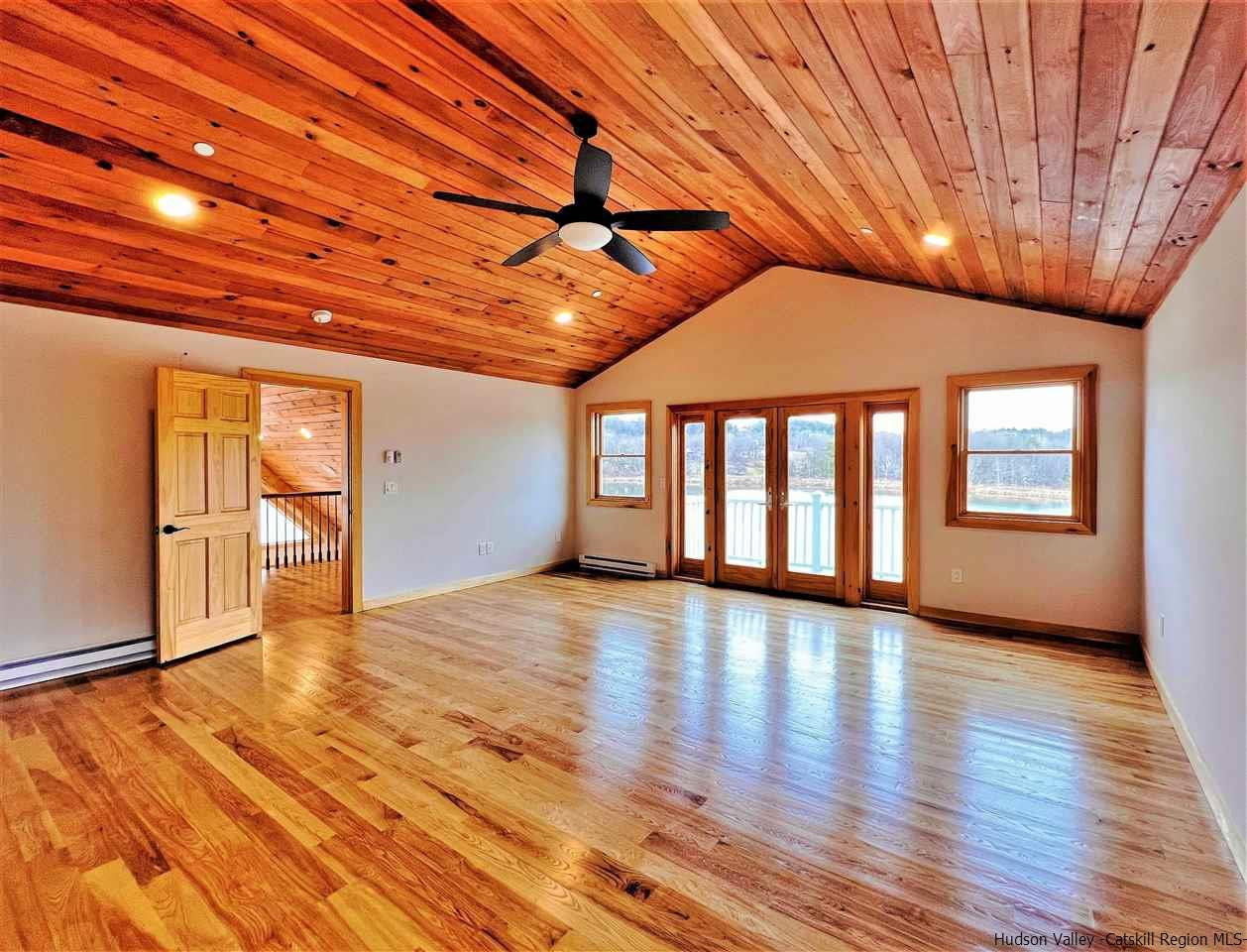 133 Rockefeller Lk Road Cairo, NY 12413 - Photo 16 of 35 an empty room with wooden floor and windows