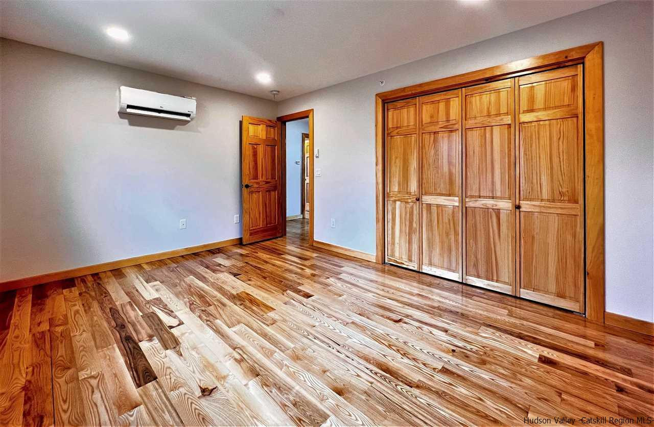 133 Rockefeller Lk Road Cairo, NY 12413 - Photo 21 of 35 a view of an empty room with wooden floor and a window