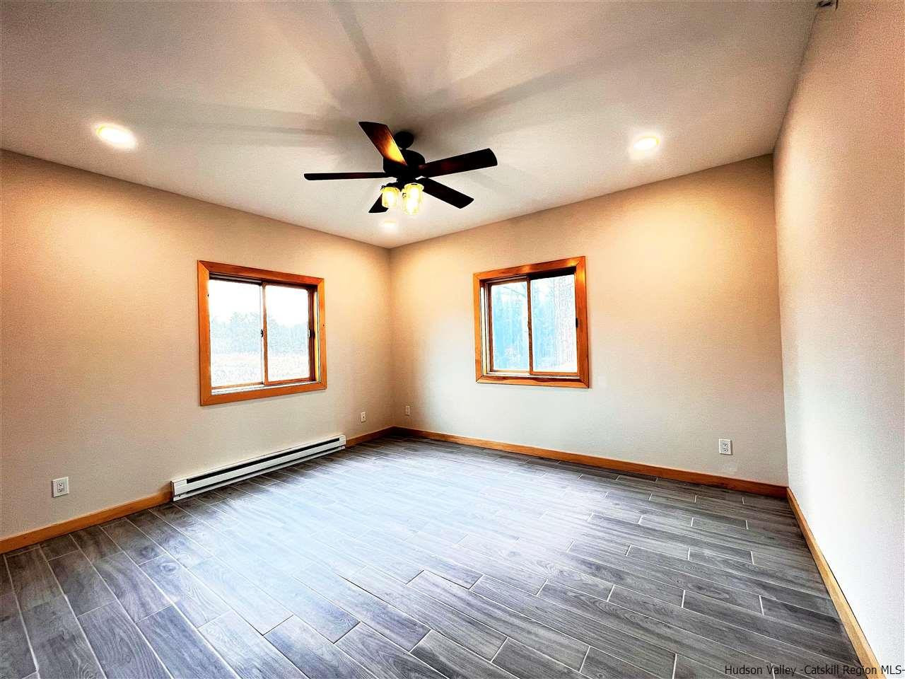 133 Rockefeller Lk Road Cairo, NY 12413 - Photo 23 of 35 an empty room with wooden floor and windows