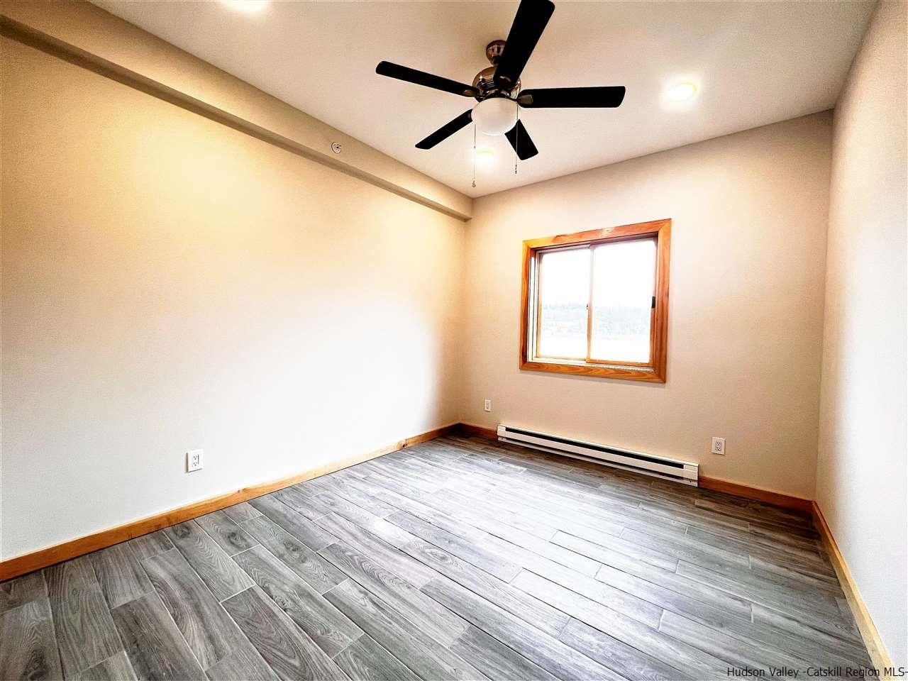 133 Rockefeller Lk Road Cairo, NY 12413 - Photo 29 of 35 an empty room with wooden floor and windows