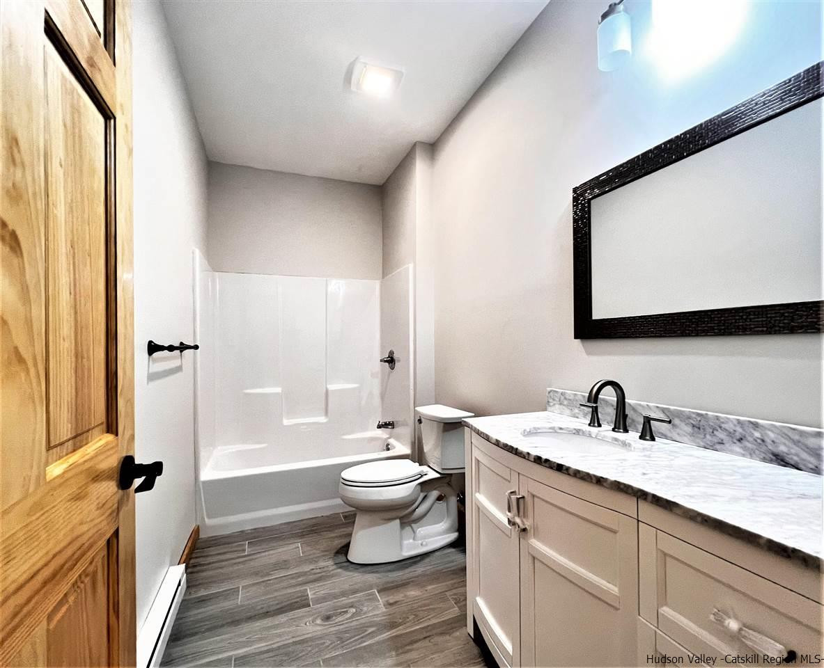 133 Rockefeller Lk Road Cairo, NY 12413 - Photo 30 of 35 a bathroom with a double vanity sink a mirror and a toilet