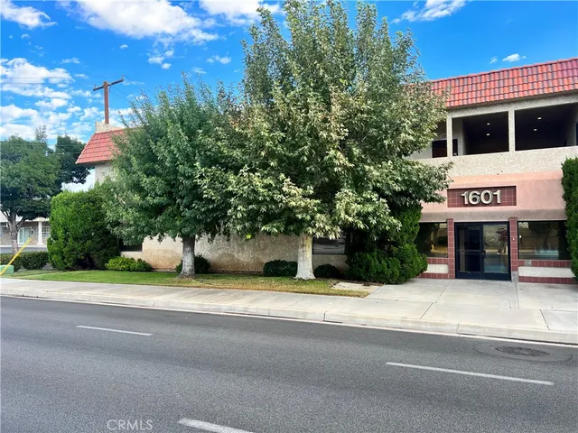 a tall yellow building with trees in front of it