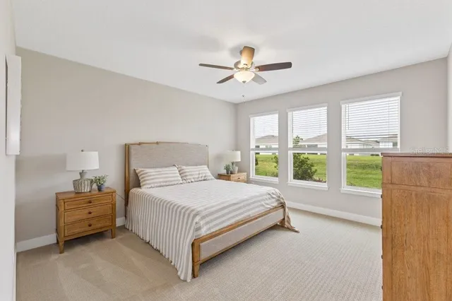 a bed sitting in a spacious bedroom next to a window