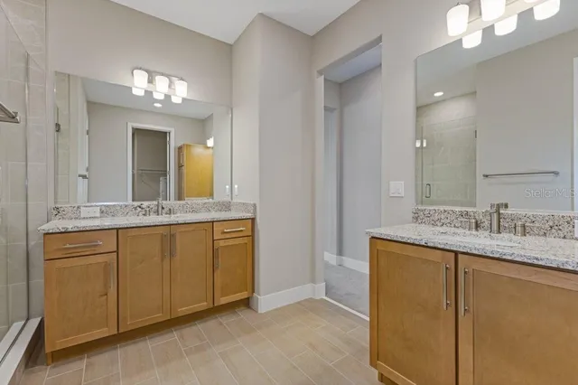 a bathroom with a granite countertop sink a large mirror and a vanity