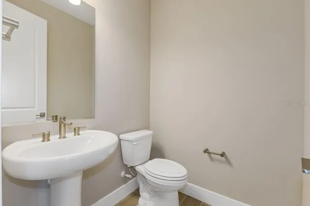 a bathroom with a sink a toilet and a mirror