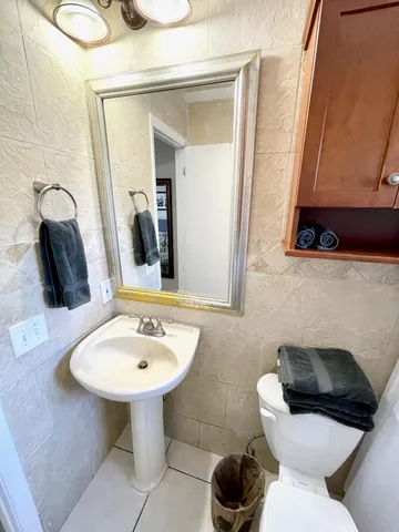 a bathroom with a toilet sink and mirror