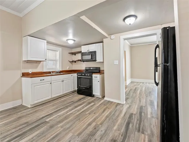 a kitchen with stainless steel appliances granite countertop a white cabinets and wooden floor