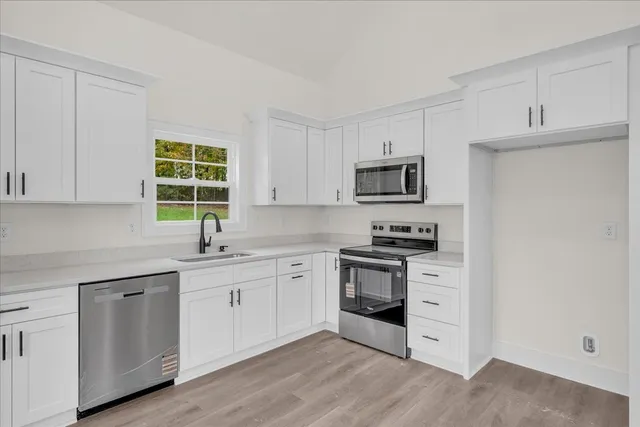 a kitchen with stainless steel appliances granite countertop a stove a sink and a microwave