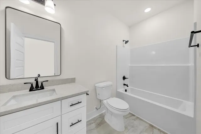 a bathroom with a toilet a sink a mirror and shower