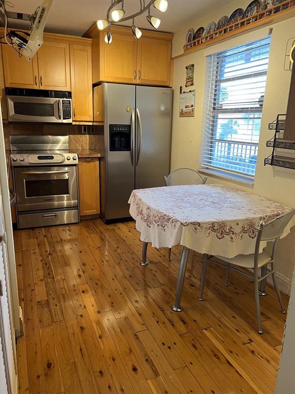 3910 Inverrary Boulevard, Unit 301B Lauderhill, FL 33319 - Photo 12 of 44 a kitchen with a table chairs refrigerator and microwave