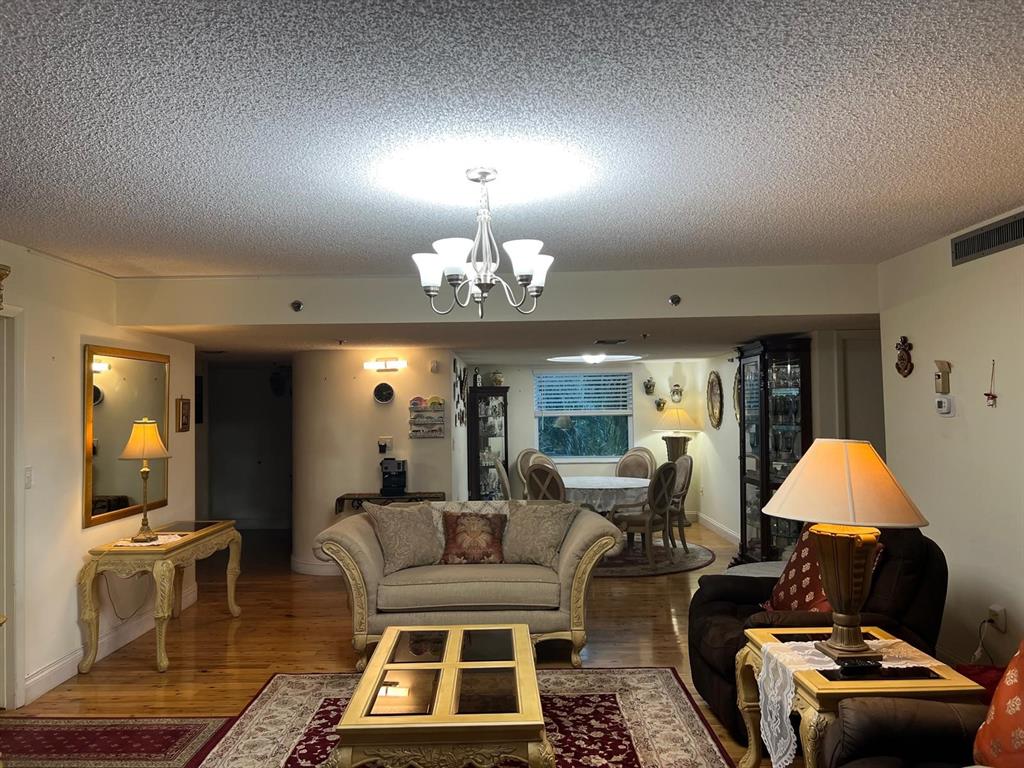 3910 Inverrary Boulevard, Unit 301B Lauderhill, FL 33319 - Photo 4 of 44 a living room with furniture a lamp and a chandelier