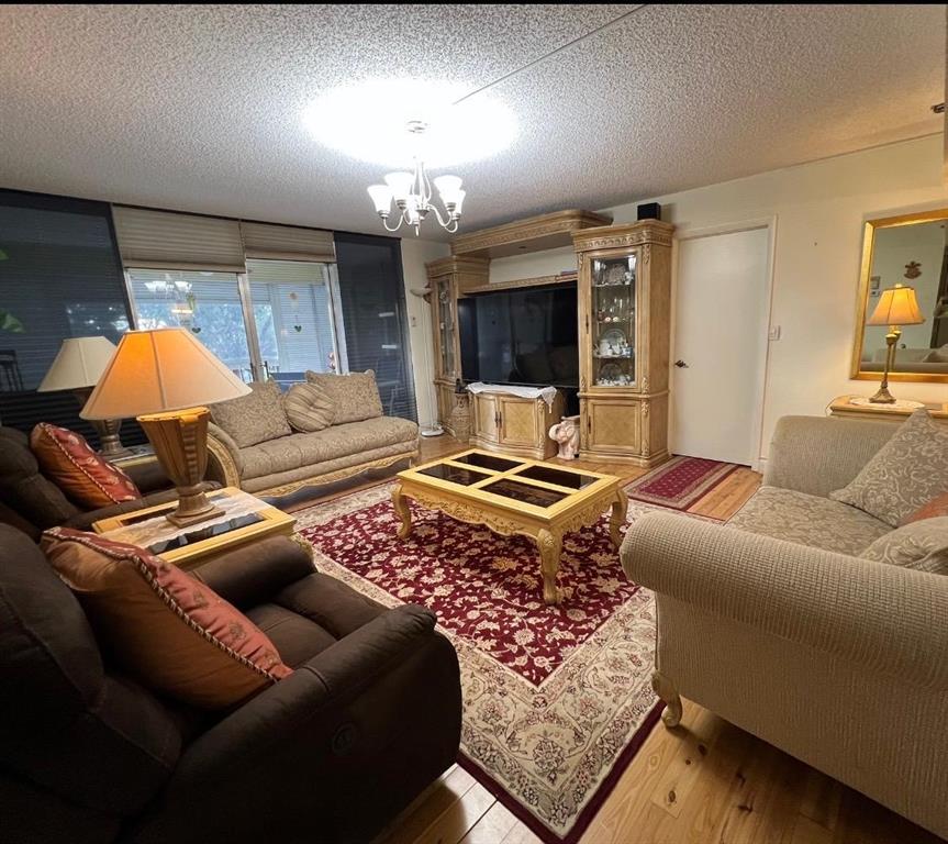 3910 Inverrary Boulevard, Unit 301B Lauderhill, FL 33319 - Photo 5 of 44 a living room with furniture and a chandelier