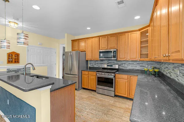 a kitchen with stainless steel appliances granite countertop a sink stove and refrigerator