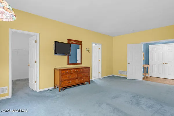 a view of an empty room with furniture and a bathroom