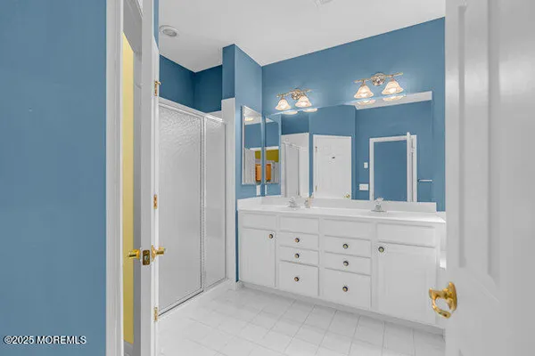 a bathroom with a sink a vanity a mirror and glass door