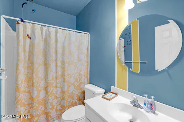 a bathroom with a sink a toilet and shower curtain