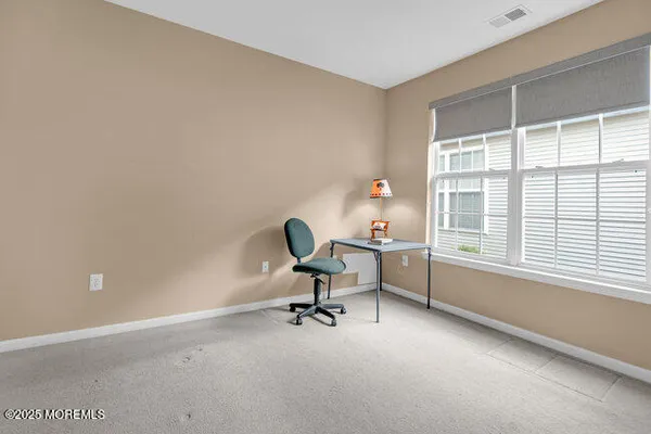 a view of a workspace with furniture and a window