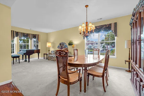 a dining room with furniture a chandelier and wooden floor