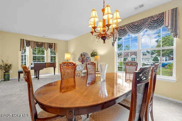 a dining room with furniture a large window and a chandelier
