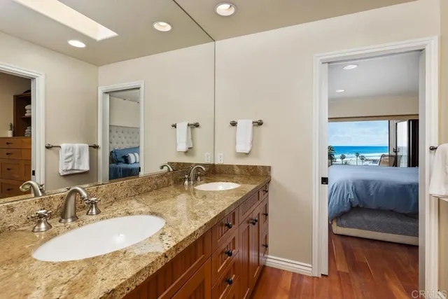 a bathroom with a granite countertop double vanity sink and a mirror