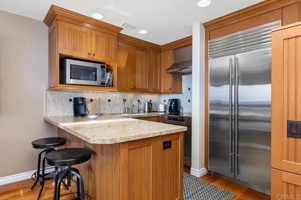 a kitchen with stainless steel appliances granite countertop a refrigerator and a stove top oven
