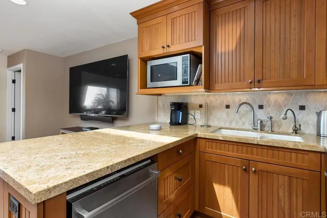 a kitchen with granite countertop a sink and a stove top oven
