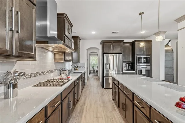 a kitchen with stainless steel appliances granite countertop a sink stove and refrigerator