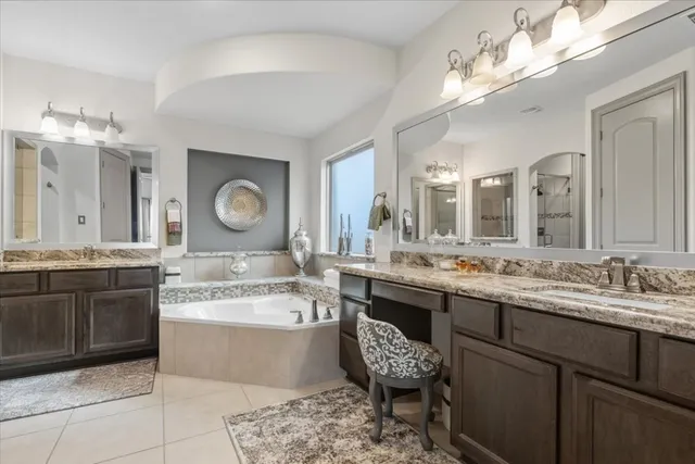 a large bathroom with a granite countertop sink a large mirror and a bathtub