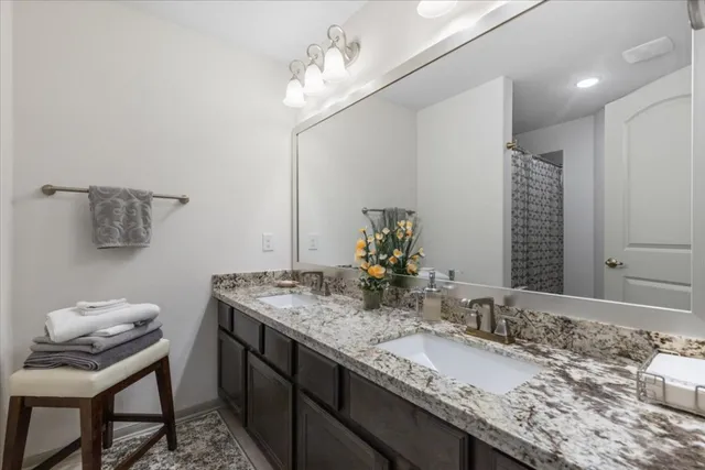 a bathroom with a granite countertop sink a toilet and a mirror