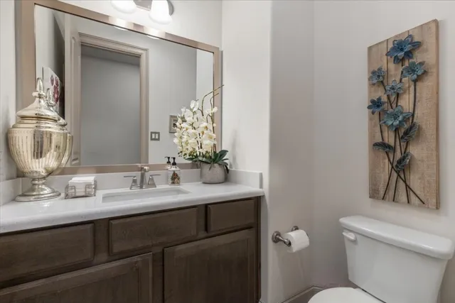 a bathroom with a granite countertop sink a toilet and a mirror