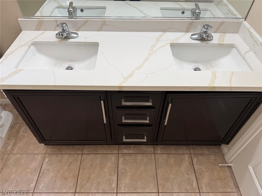 3962 Coyote Ridge Court Las Vegas, NV 89129 - Photo 22 of 35 A sleek double vanity features rich dark cabinetry beneath pristine quartz countertops and undermount sinks.