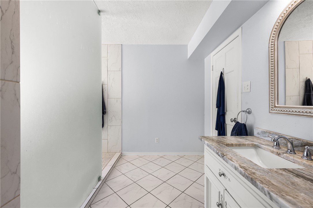 871 Cazey Loop Franklin, TX 77856 - Photo 30 of 42 a bathroom with a granite countertop sink and a mirror