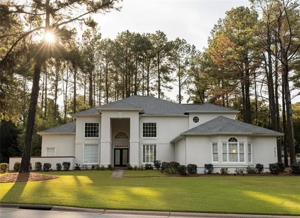 a dining room with wooden floor a chandelier a wooden table and chairs