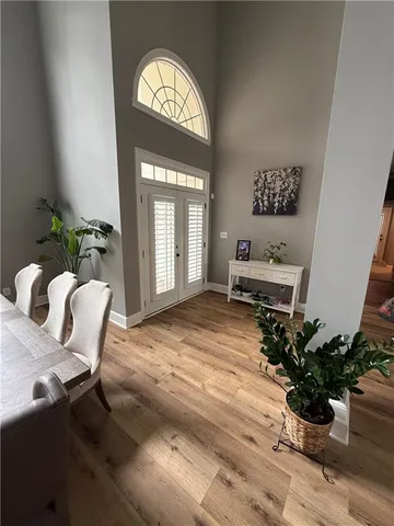 a dining room with wooden floor a chandelier a wooden table and chairs
