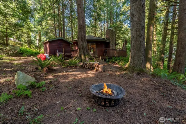 a view of a wooden house with a yard and sitting area