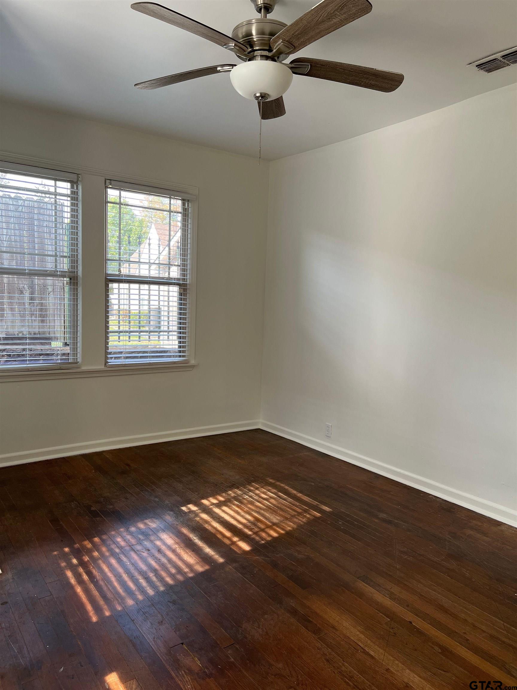 328 Mockingbird Lane Tyler, TX 75701 - Photo 8 of 12 a view of an empty room with wooden floor and a window