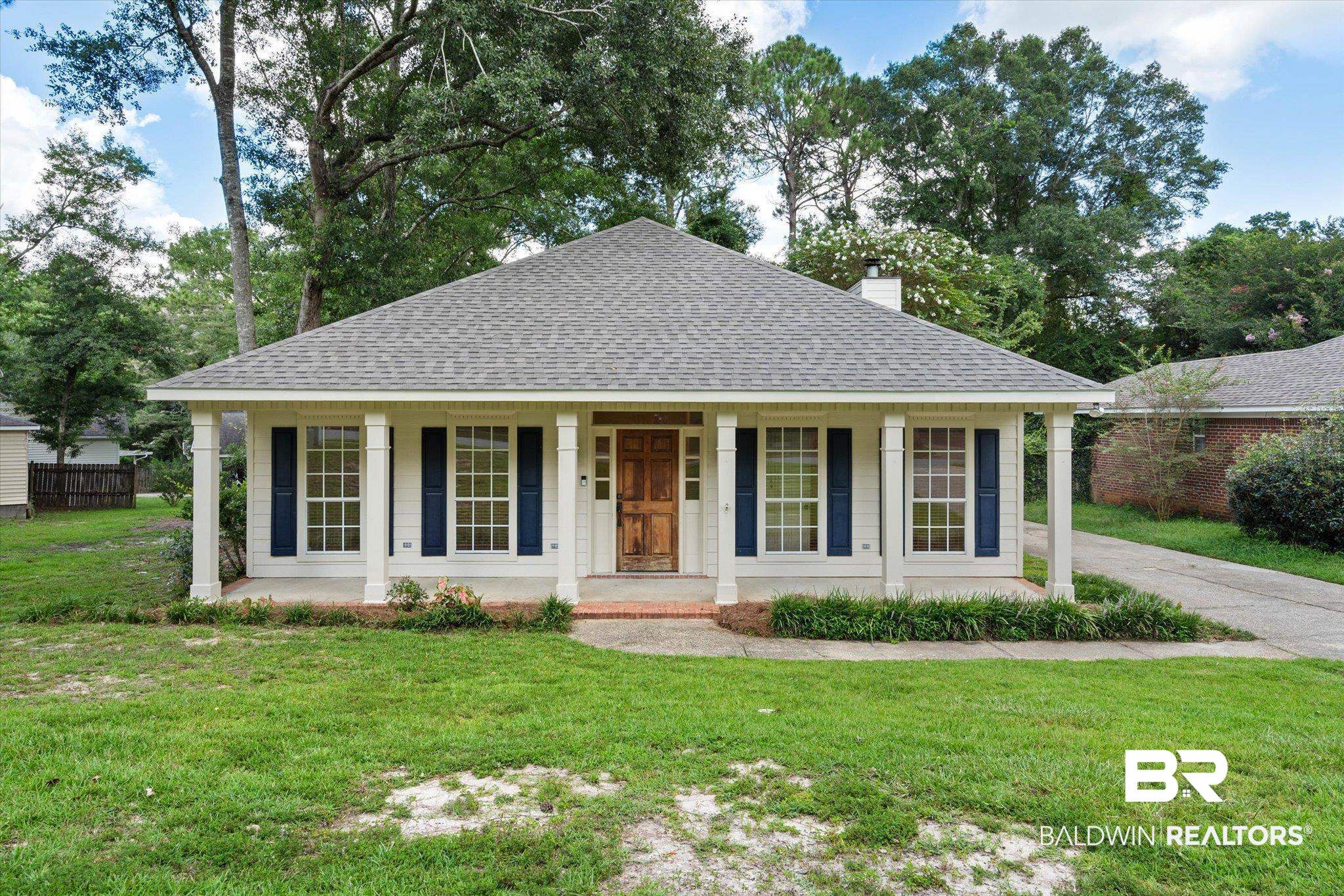 3032 Autumn Ridge Drive West Mobile, AL 36695 - Photo 1 of 20 View of front of house featuring a shingled roof, a porch, a chimney, and a front yard